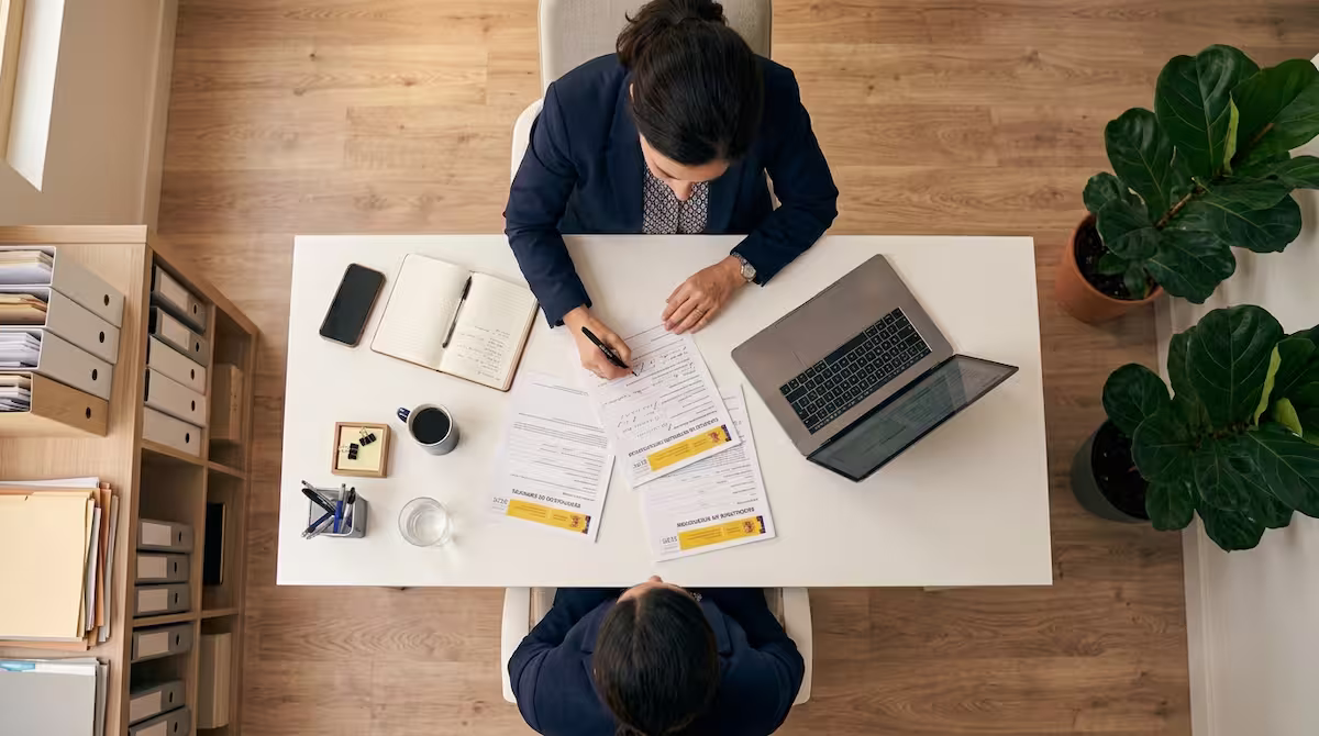 Persona revisando documentos oficiales del SEPE sobre causas de pérdida del paro en España.