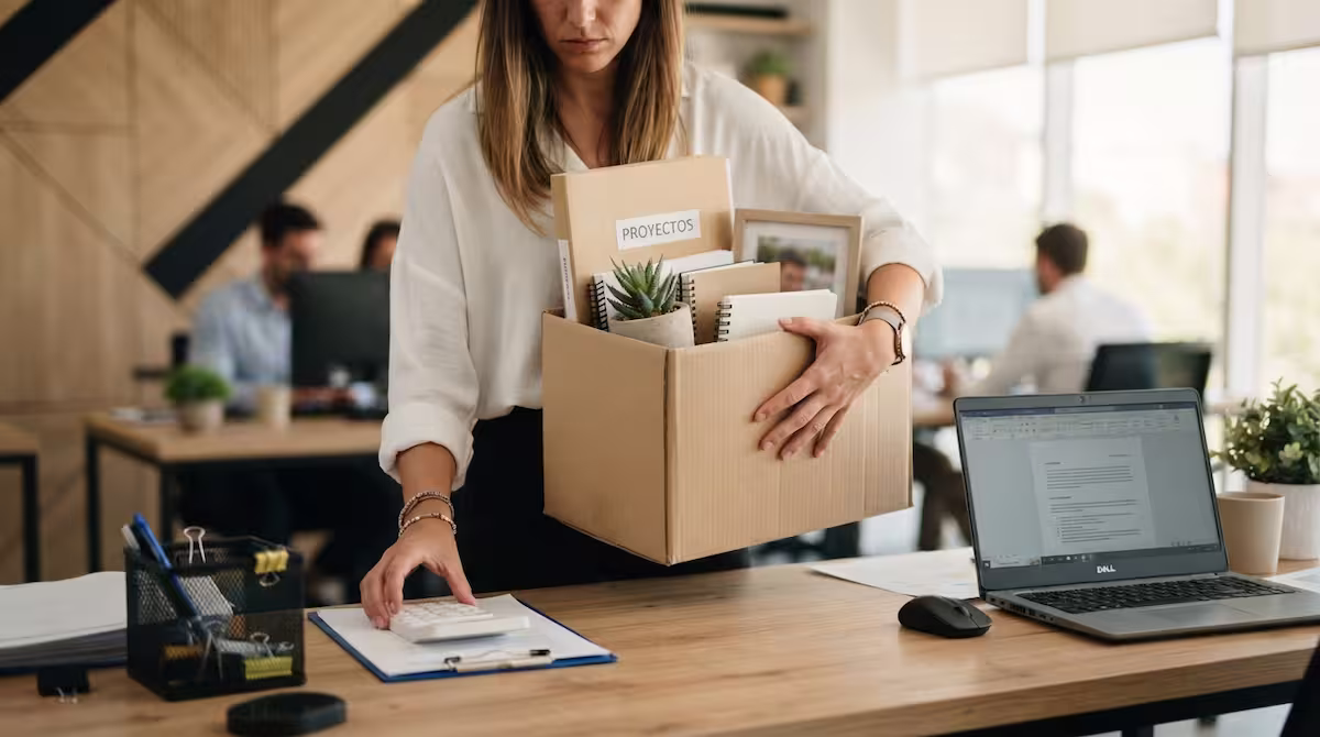 mujer recogiendo sus pertenencias después de un despido disciplinario